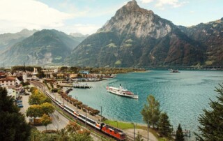 Gotthard Panorama Express mit See und Bergen im Hintergrund