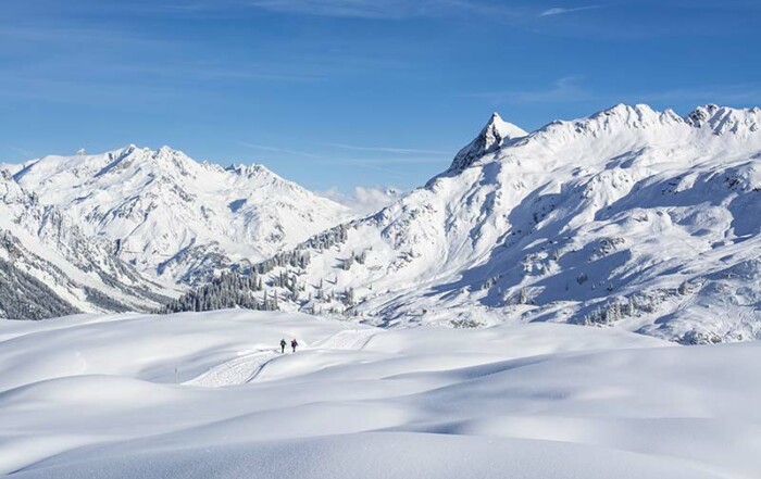 2 Skilangläufer in den Bergen mit Schnee